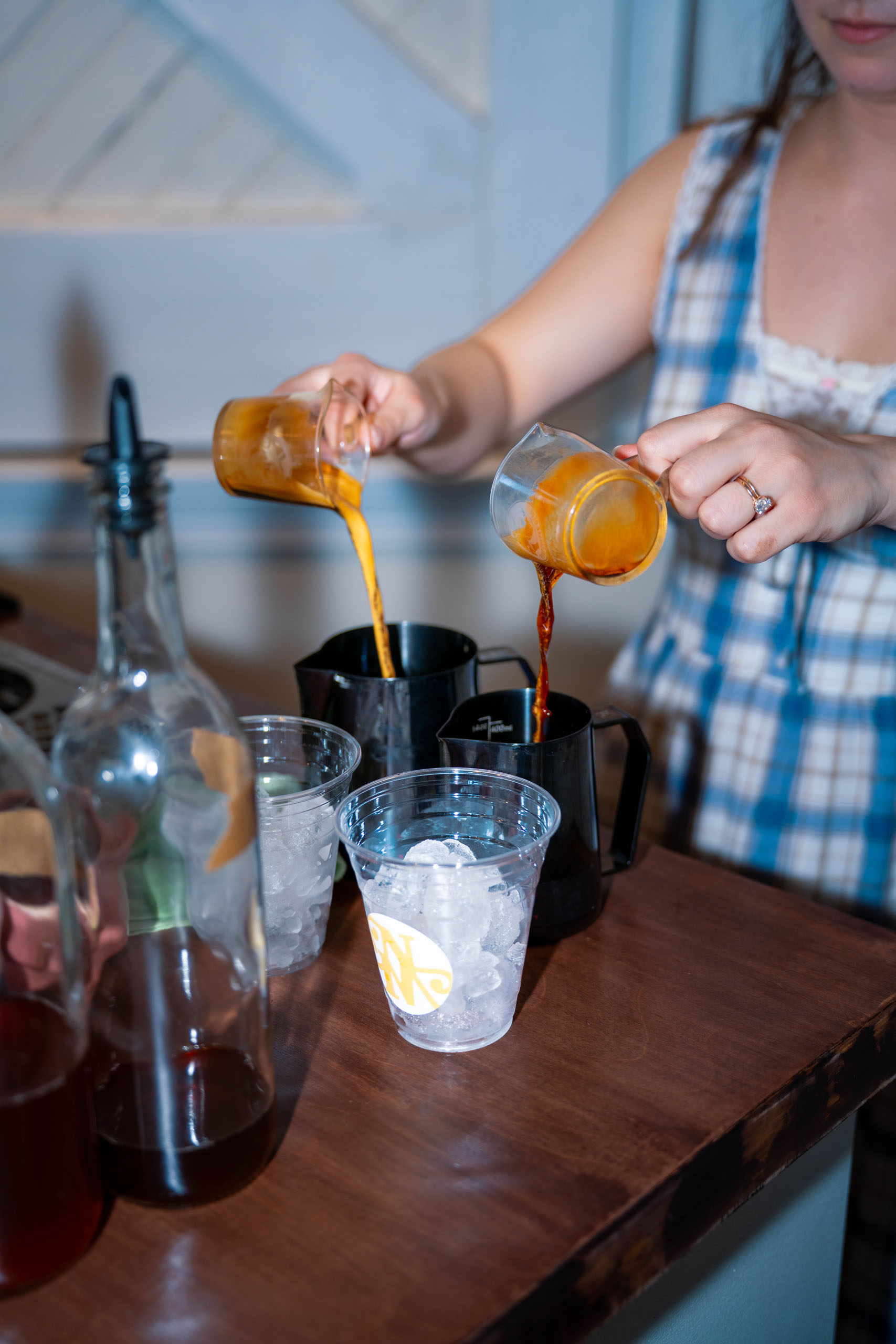 A New Mornings Coffee barista pouring fresh espresso over ice to prepare a specialty iced coffee drink at a private event
